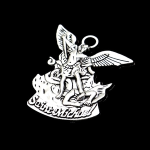 Macro shot of silver Saint Michael pendant showing intricate details on black background