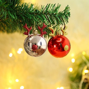 Christmas reindeer ornaments in silver and red with glitter antlers on tree branch