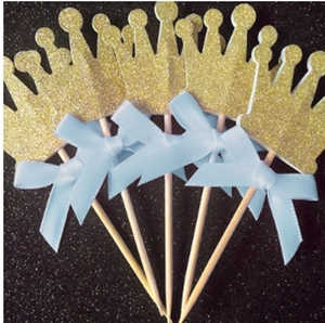 Golden glitter crown cake toppers with light blue satin bows for birthday party decor