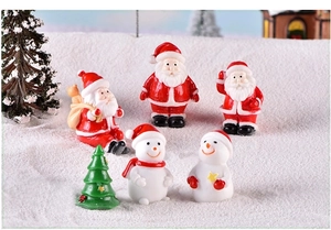 Detailed view of six miniature Christmas resin figurines on a snowy decorative surface
