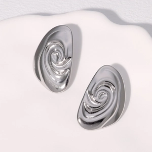 Minimalist silver spiral stud earrings in a modern abstract conch design on white tray