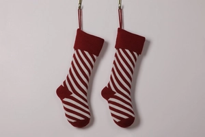 Detail of two knitted red and white striped Christmas stockings with hanging loops