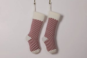 Detail showing two red and white striped knitted Christmas stockings with white cuffs