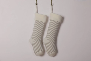 Detail of beige and light gray striped knitted Christmas stockings with hanging loops