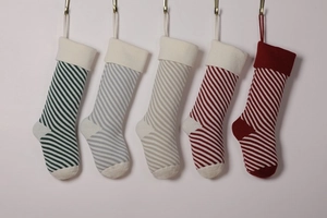 Detail of five hanging knitted Christmas stockings with various colorful striped patterns