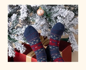 Calze natalizie in lana blu navy con motivi a renne in un'ambientazione festiva regalo