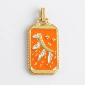 Macro shot of rectangular gold-plated tarot pendant with orange enamel and star details