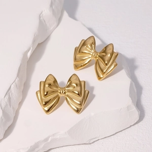 Minimalist gold bow earrings in tiered design on natural white stone base