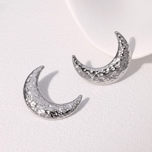 Hammered silver crescent moon earrings in stainless steel on a minimalist background