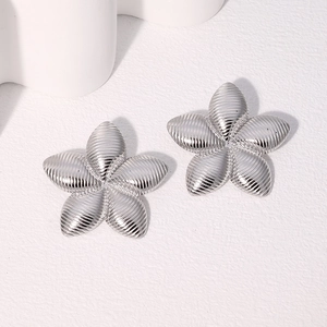 Detailed view of silver five-petal flower stud earrings in polished stainless steel