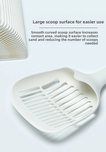 Détail d'une grande pelle à litière crème avec fentes et poignée ergonomique longue