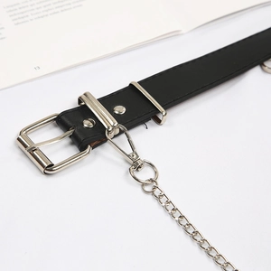 Detailed macro view of black punk belt featuring silver metal eyelets and a detachable chain