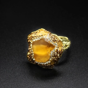 Macro detail of vintage gold ring featuring raw purple amethyst and small brown crystals