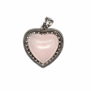 Close-up of pink crystal heart pendant with textured silver metallic bezel on white background