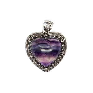 Macro shot of heart-shaped purple fluorite pendant with vintage silver patterned border
