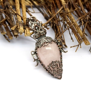 Detailed view of pink crystal pendant in antique copper hollow filigree star frame