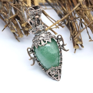 Detail of green crystal pendant with vintage copper filigree and engraved star pattern