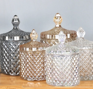 Diamond-patterned crystal glass jars in various colors on a wooden surface for decor
