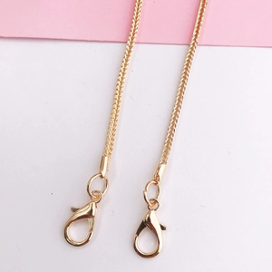Detail of a bright gold braided metal chain with lobster clasps for mobile bags