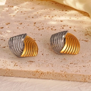 Two-tone fan-shaped stainless steel earrings with radial texture on stone background