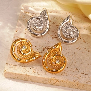 Elegant gold and silver conch snail stud earrings with sparkling crystals on stone