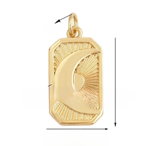Macro shot of 17x11mm gold rectangular pendant with embossed sun and moon celestial motif