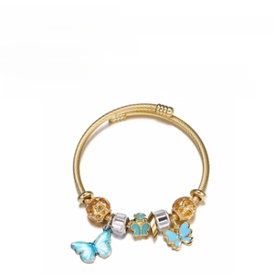 Detailed macro view of gold-colored stainless steel bracelet with blue butterfly charms