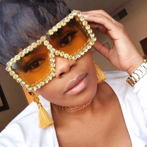 Detail of oversized square rhinestone sunglasses with stylish yellow tinted lenses