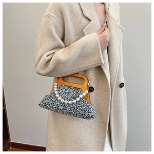 Detail of grey wool-blend bag with wooden handle and elegant pearl chain accessory