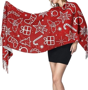 Detail of red Christmas scarf featuring white festive trees, candy canes and fringe tassels