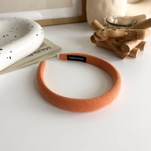 Detail of orange padded fabric headband with handmade label and soft matte finish