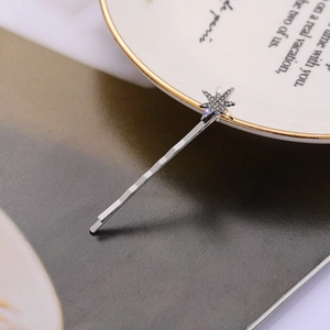 Détail d'une barrette étoile argentée avec strass scintillants sur une assiette élégante