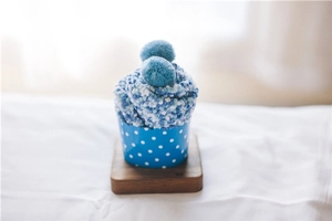 Detailed texture of blue coral fleece cake socks with soft pompoms in cupcake paper