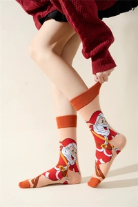 Detail of knitted Christmas socks with Santa Claus pattern on beige background