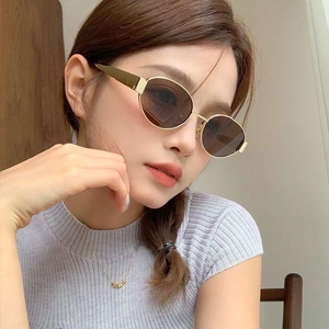 Close-up of stylish gold metal frame polarized sunglasses worn by a fashion model