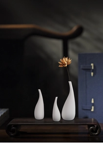 Juego de tres jarrones de cerámica blanca mate con un diseño minimalista de gota