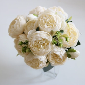 Close-up of cream white silk peonies and roses with realistic green buds and leaves