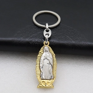 Macro detail of bimetal Virgin of Guadalupe religious keychain on black leather