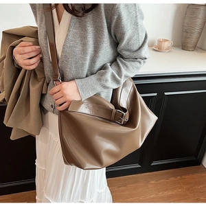 Détail de la bandoulière large réglable avec boucle en métal sur un grand sac cabas