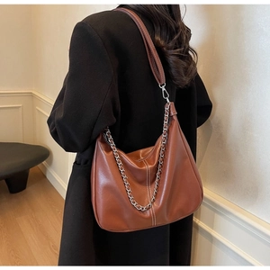 Detailed side view of a brown vintage leather hobo bag with decorative silver chain strap