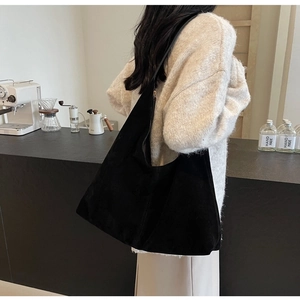 Chic black large hobo bag shown on shoulder in a cozy cafe setting for daily commute