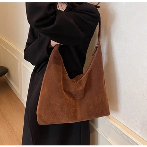 Detail view of large dark brown suede hobo bag styled for high-end commuter outfits