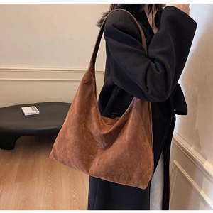 Brown matte suede tote bag styled with a black coat in a modern minimalist interior