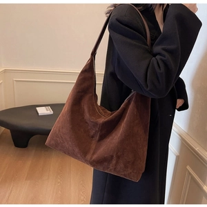 Brown suede hobo bag shown from a side view on model for a premium minimalist look
