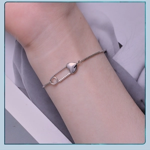 Close-up of S925 sterling silver heart safety pin bracelet with cubic zirconia accents