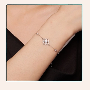 Close-up of s925 silver bracelet with sparkling moissanite clover pendant on a wrist