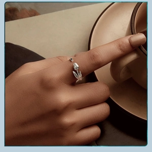 Close-up of silver tulip flower open ring on hand with elegant aesthetic background
