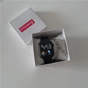 Close-up of LED sport watch and engraved metal bracelet set in a white gift box