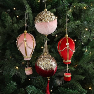 Velvet hot air balloon and glittery ball ornaments on a decorated Christmas tree
