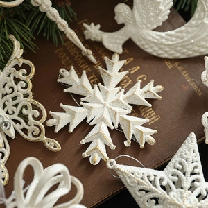 Creamy white Christmas ornaments with glitter coating on vintage books and pine needles